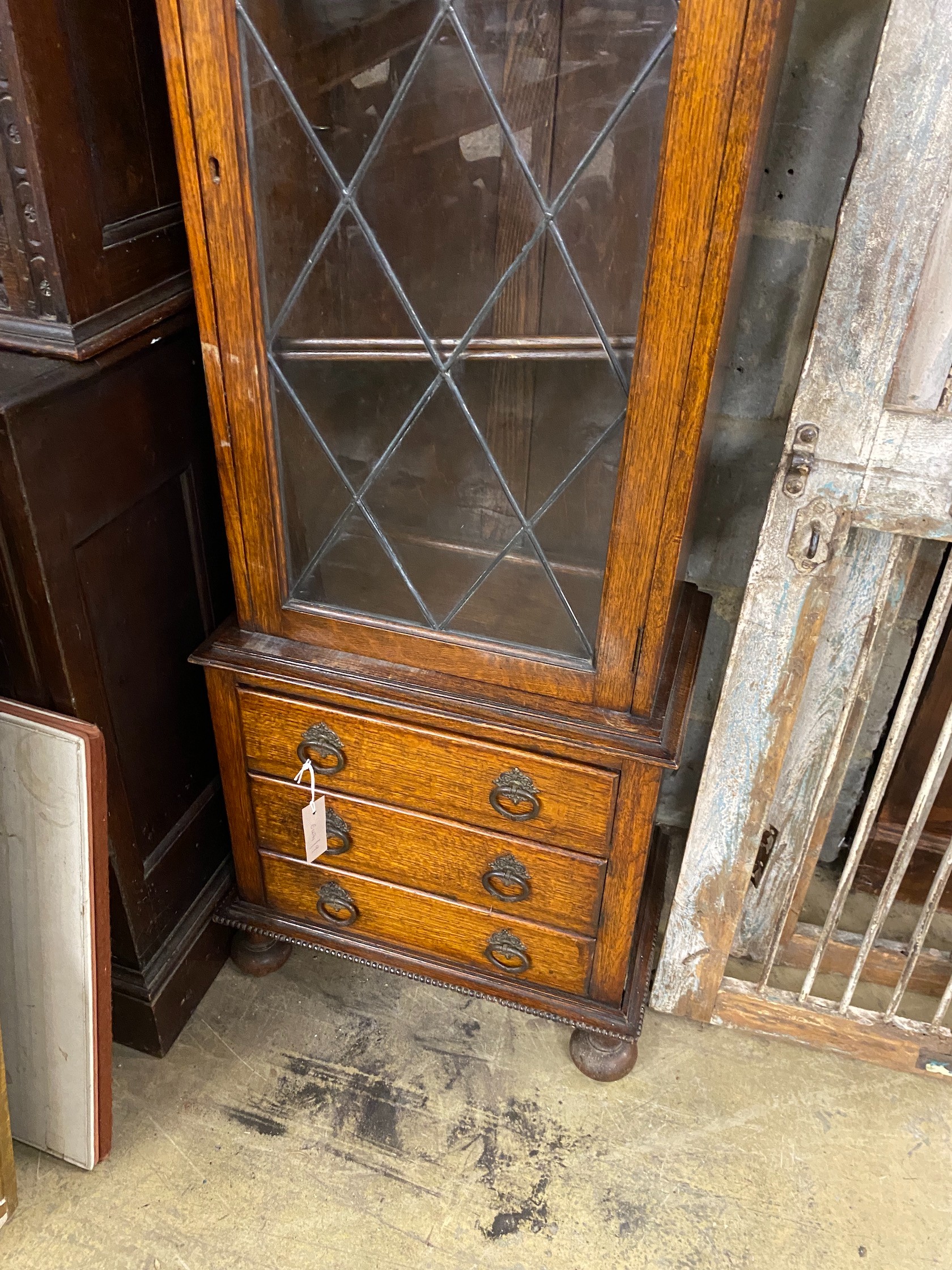 A 1920's narrow oak leaded glazed bookcase, width 52cm, depth 32cm, height 151cm